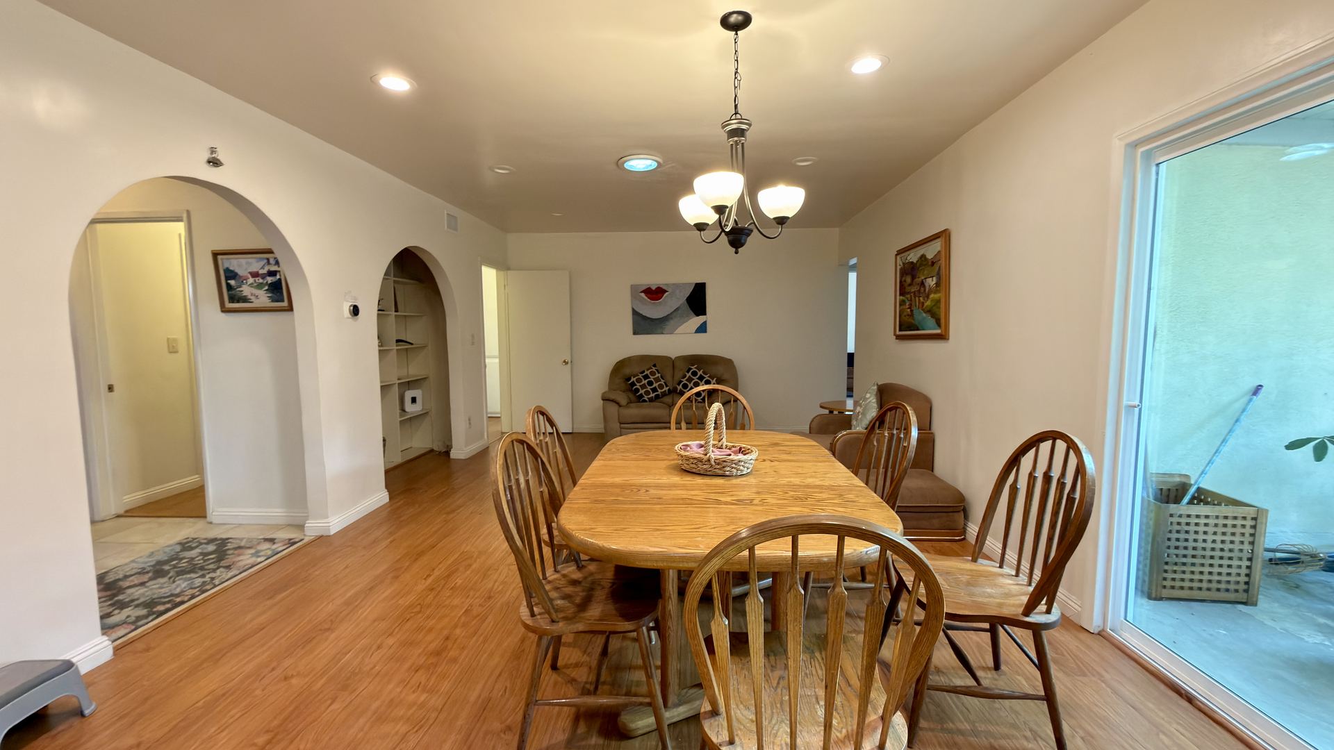 Dining area at 9621 Jumilla Ave with arched openings, chandelier and slider to the patio